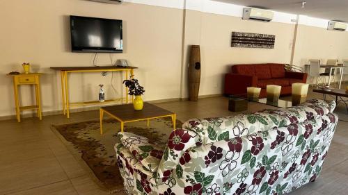 a living room with a couch and a table at Pousada Brisas da Serra in Serra do Cipo