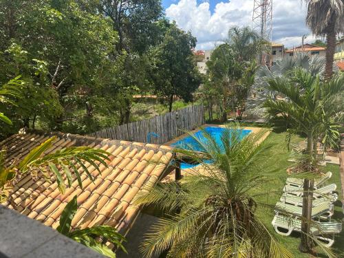 a backyard with a swimming pool and palm trees at Pousada Brisas da Serra in Serra do Cipo