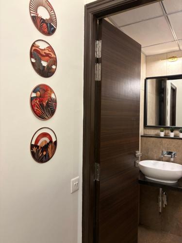 a bathroom with a wooden door and plates on the wall at Casa Lobo in Mapusa