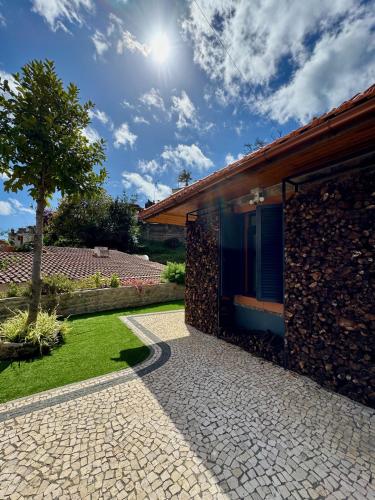 a house with a stone walkway next to a building at Casa Flor do Monte in Funchal
