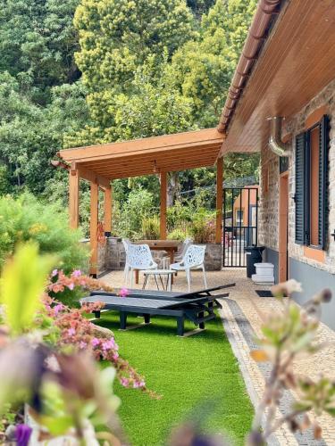 a patio with a picnic table and chairs on the grass at Casa Flor do Monte in Funchal