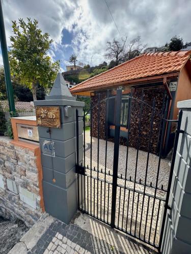 a gate in front of a house with a building at Casa Flor do Monte in Funchal