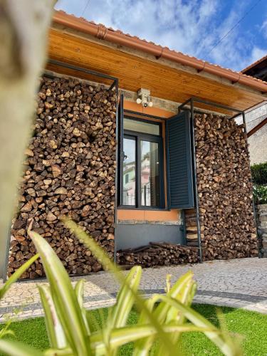 a building with a door and a pile of fire wood at Casa Flor do Monte in Funchal