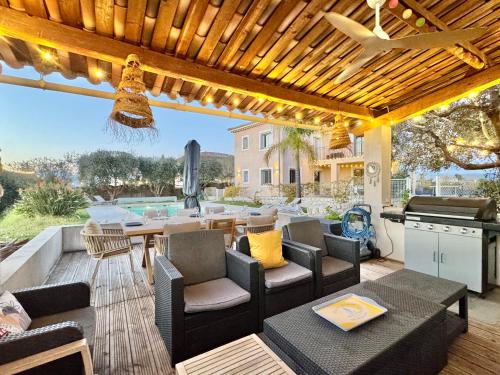 a patio with a wooden pergola and a table and chairs at Villa SYAGRUS - Easy Home Booking in Nice