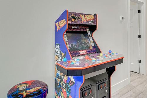 a video game machine in a room with a stool at 1mi to Downtown! 3BR6BedsScreenroom,Deck,Firepit in St. Augustine
