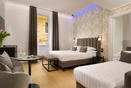 a hotel room with two beds and a couch at Hotel Patria in Rome