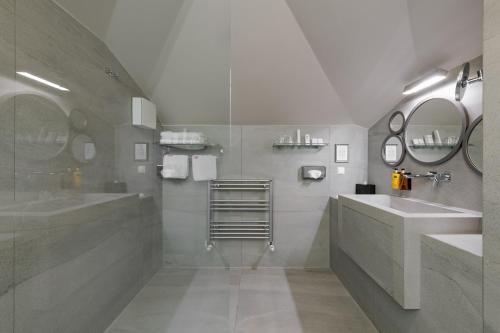 ein Badezimmer mit zwei Waschbecken und zwei Spiegeln in der Unterkunft Bastion Heritage Hotel in Zadar