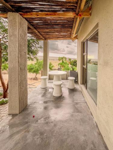 a patio with a table and a view of the ocean at Carlo's Mountain Lodge in Usakos