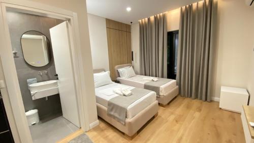 a hotel room with two beds and a sink at Hotel Metali - City Centre in Sarandë