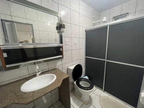 a bathroom with a toilet and a sink and a mirror at Pousada Casamar in Maceió
