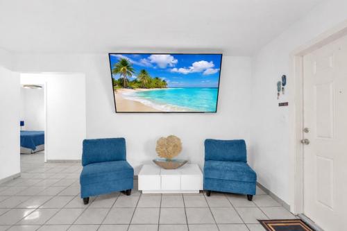 two blue chairs and a table in a room at Relaxing Miami Retreat with Canal View and a Central Location in Miami