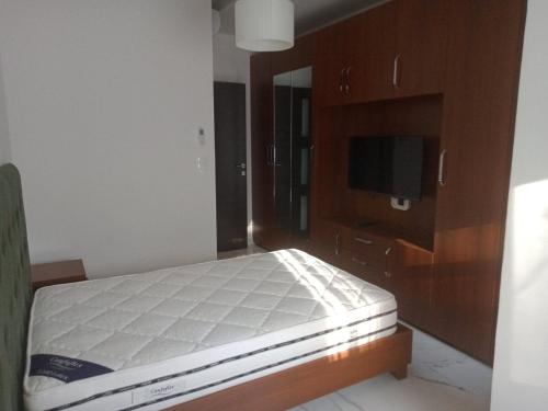 a bedroom with a bed and a flat screen tv at L'appartement en face de la baie in Sidi MʼHamed