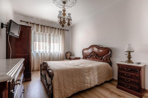 a bedroom with a bed and a dresser and a television at Casa do Centro in Peniche