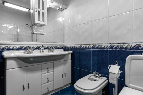 a bathroom with a white sink and a toilet at Casa do Centro in Peniche