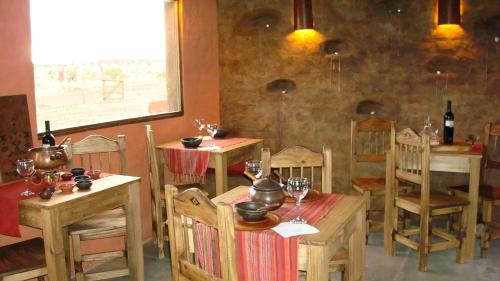 un restaurante con mesas de madera y sillas con copas de vino en Mamuna Casas Loft en Uspallata