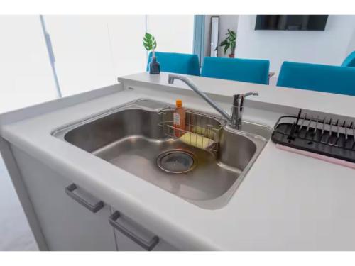 a sink in a kitchen with blue chairs at Turtle Two Three - Vacation STAY 87759v in Miyako-jima