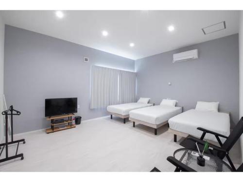 a living room with white furniture and a flat screen tv at Turtle Two Three - Vacation STAY 87759v in Miyako-jima