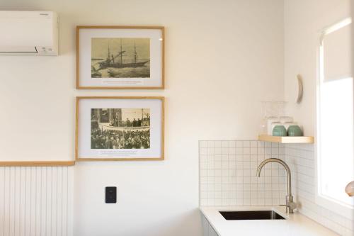 a kitchen with three framed pictures on the wall at The Sea Breeze in Timaru