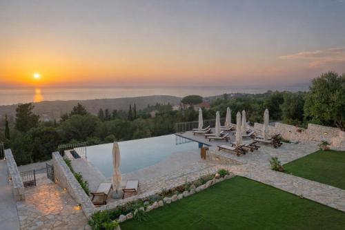 a pool with umbrellas and a view of the ocean at Hellosummer Boutique suites,near fiscardo! in Andipáta Erísou
