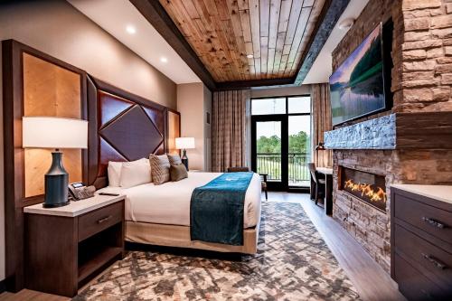 a bedroom with a bed and a fireplace at Choctaw Landing Casino & Resort, Trademark Coll by Wyndham in Broken Bow