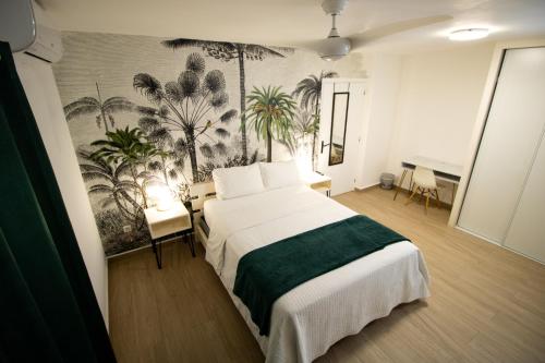 a bedroom with a bed and a mural of palm trees at Over The Hill Residence - Your Tranquil Oasis in Grand Case