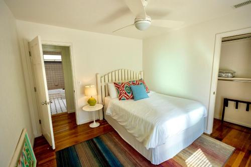a bedroom with a white bed with pillows on it at Beachbound Bliss in Del Mar in San Diego