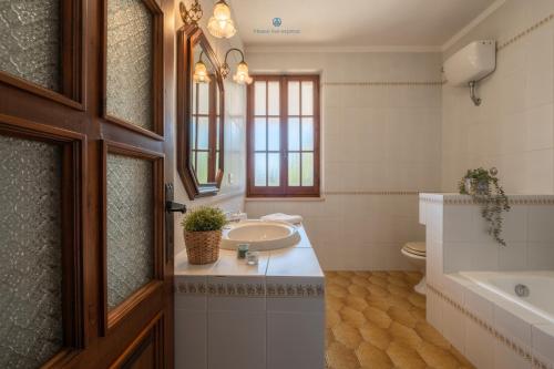 a bathroom with a sink and a tub and a toilet at Domo de Iannas-House Live Express in Quartu Sant'Elena