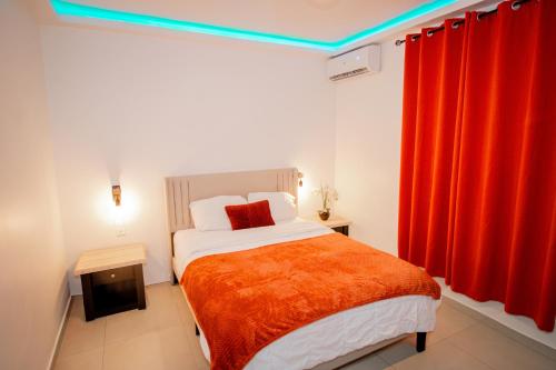 a bedroom with a bed and red curtains at Over The Hill Residence - Your Tranquil Oasis in Grand Case