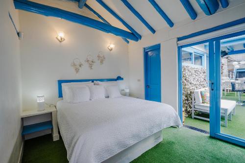 a bedroom with a white bed and a blue ceiling at Casa azul in Villa de Leyva