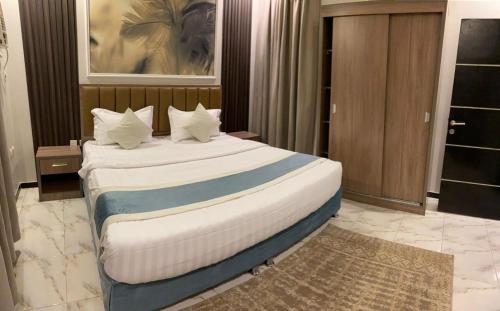 a bedroom with a large bed with white pillows at دارين1 - اوبرا جولد سابقا in Muhayil