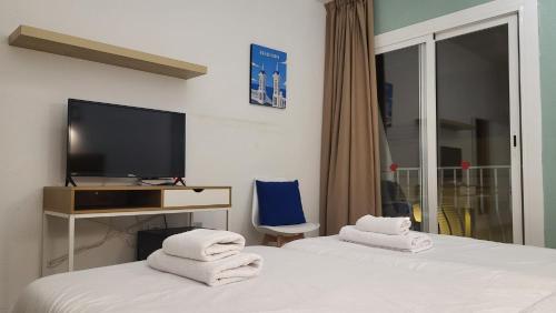 a hotel room with two beds and a television at Hotel Molí Beach in Benidorm