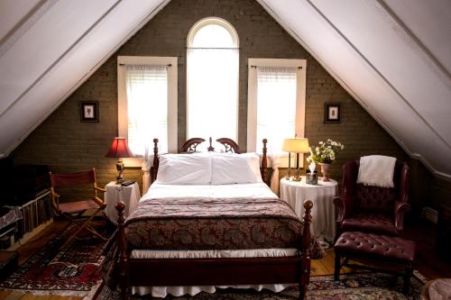 una camera da letto con un letto e due sedie in mansarda di Clifford House Private Home B&B a Cleveland