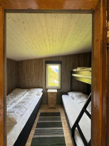 two bunk beds in a room with a window at Raaum Gard, hytte 3 in Luster