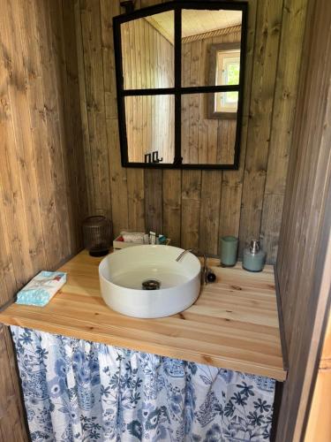 a bathroom with a white sink on a wooden counter at Raaum Gard, hytte 3 in Luster