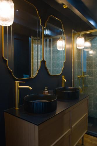 two sinks in a bathroom with two mirrors at Blue dream in Carantec