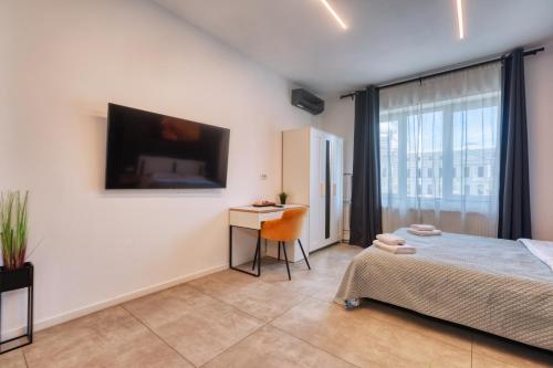 a bedroom with a bed and a desk and a tv at Old Town Apartments Brătianu - City Center Stay in Bucharest