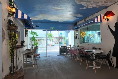 a restaurant with a blue ceiling and tables and chairs at Days Inn by Wyndham Playa del Carmen in Playa del Carmen