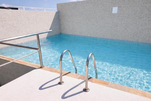 a swimming pool with blue water in a building at Days Inn by Wyndham Playa del Carmen in Playa del Carmen