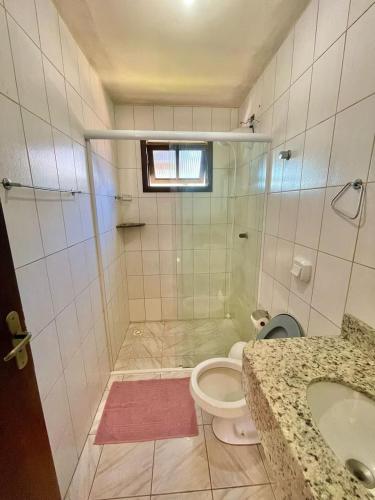 a bathroom with a shower and a toilet and a sink at 3 400m Centro de Bombinhas in Bombinhas