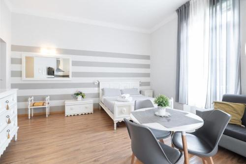 a white room with a bed and a table at Camera Tua - Falloppio 44 Rooms in Padova