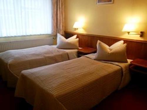a hotel room with two beds and a window at Brocki's Hotel Stadt Hamburg in Parchim