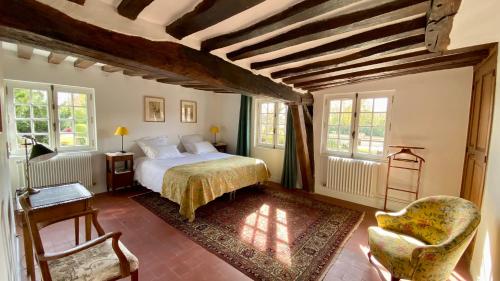 a bedroom with a bed and a chair at Le Clos des Grands Jardins in Giverny