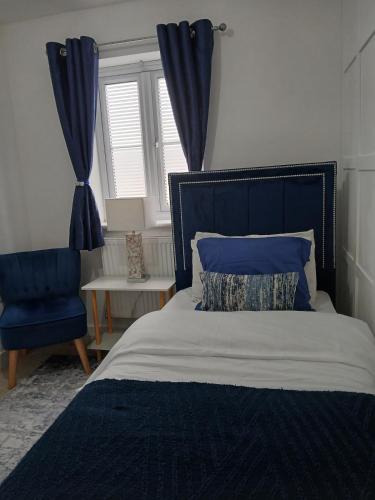 a bedroom with a bed and a blue chair at Anchored Homes in Spalding