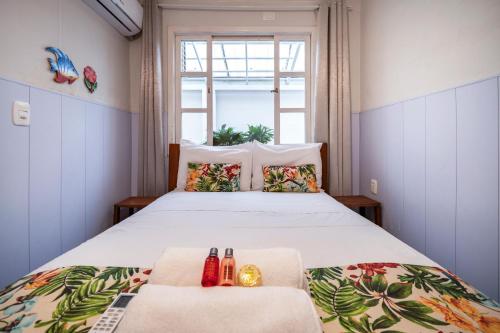 a bedroom with a large bed with a window at Mares e Flores by OlaMar Bombinhas in Bombinhas