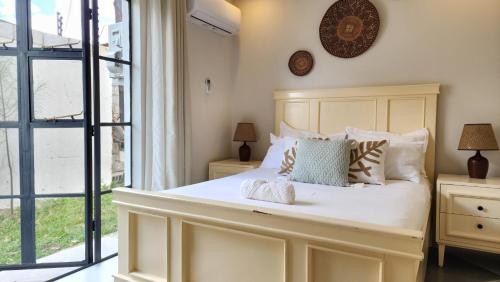 a bedroom with a large white bed and a window at Peter's Nest in Livingstone