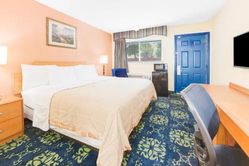 um quarto de hotel com uma cama e uma televisão de ecrã plano em Travelodge by Wyndham Ruidoso em Ruidoso