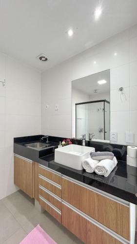 a bathroom with a sink and a large mirror at Studio Aconchegante com Vista do 33º Andar in Campo Grande