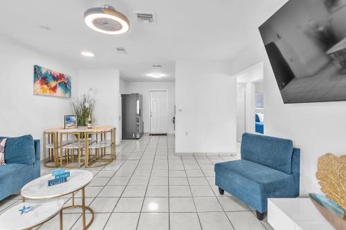a living room with two blue chairs and a tv at Relaxing Miami Retreat with Canal View and a Central Location in Miami
