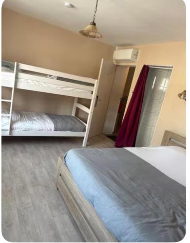 a bedroom with two bunk beds and a fan at Chambre Confort 4 personnes in Toul