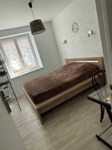 a bed in a room with a clock on the wall at Chambre Confort 4 personnes in Toul